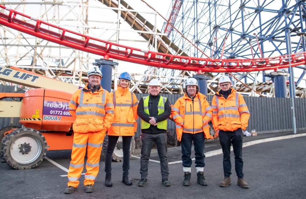 Taziker team in PPE in front of the Big One rollercoaster.