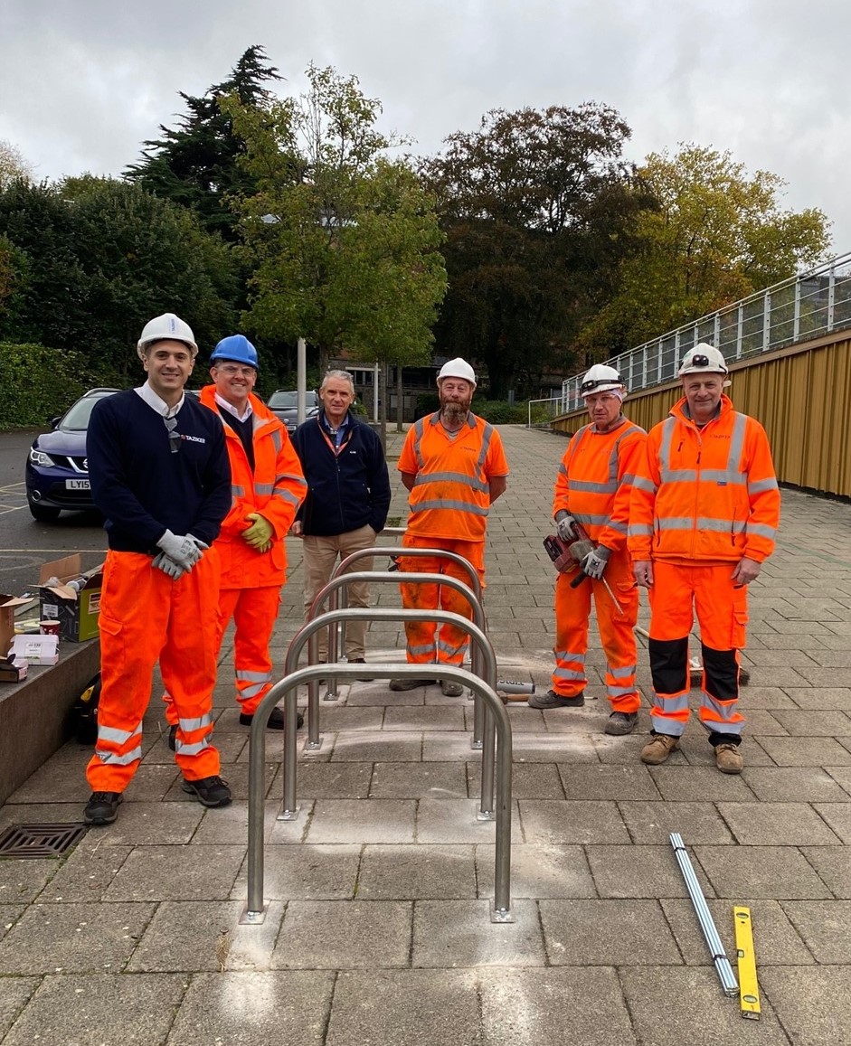 Taziker team standing around newly installed cycle hoops at local school.