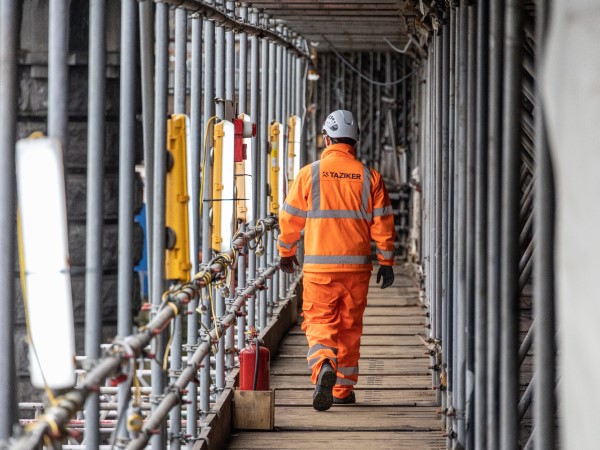 Taziker operative walking through scaffolding on Clyde Bridge.