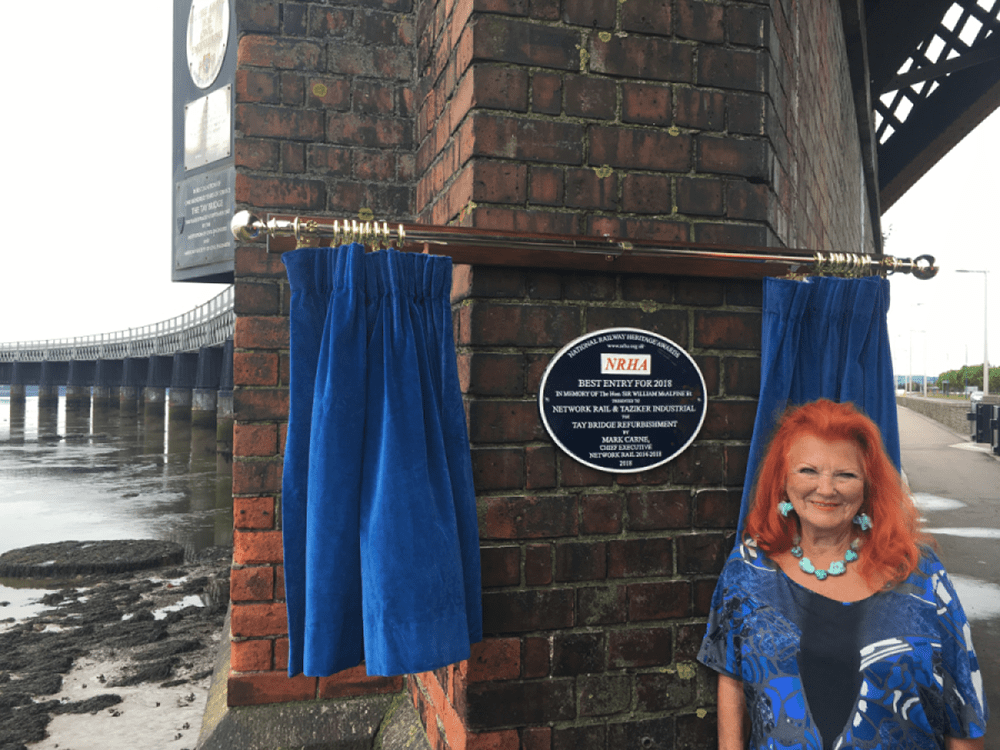 Lady McAlpine next to the Tay Bridge commemorative plaque.