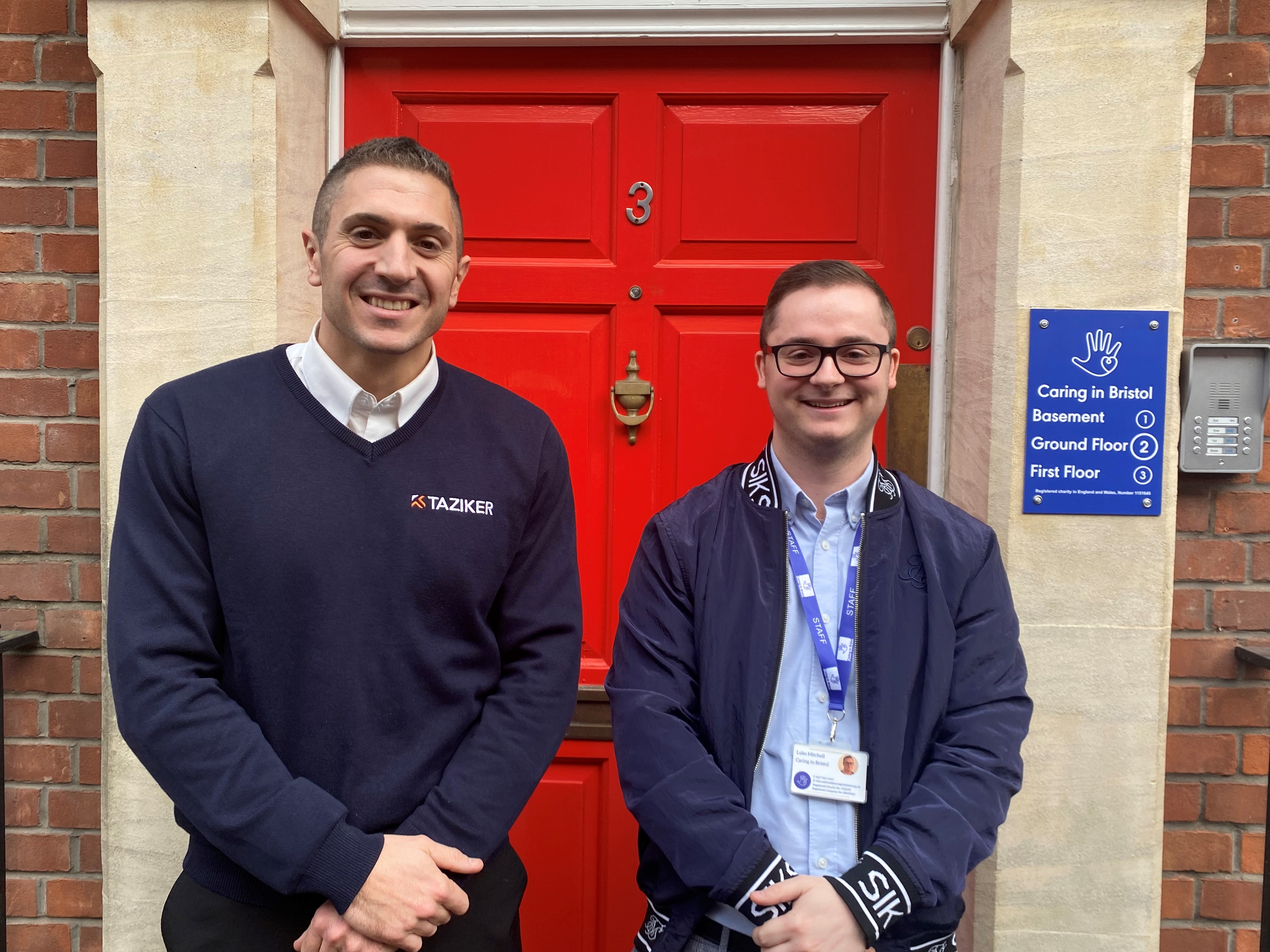 Taziker's Business Development Director, Tom Nicotra, and Caring in Bristol's Corporate and Community Partnerships Coordinator, Luke Mitchell, smiling outside Caring in Bristol's office.