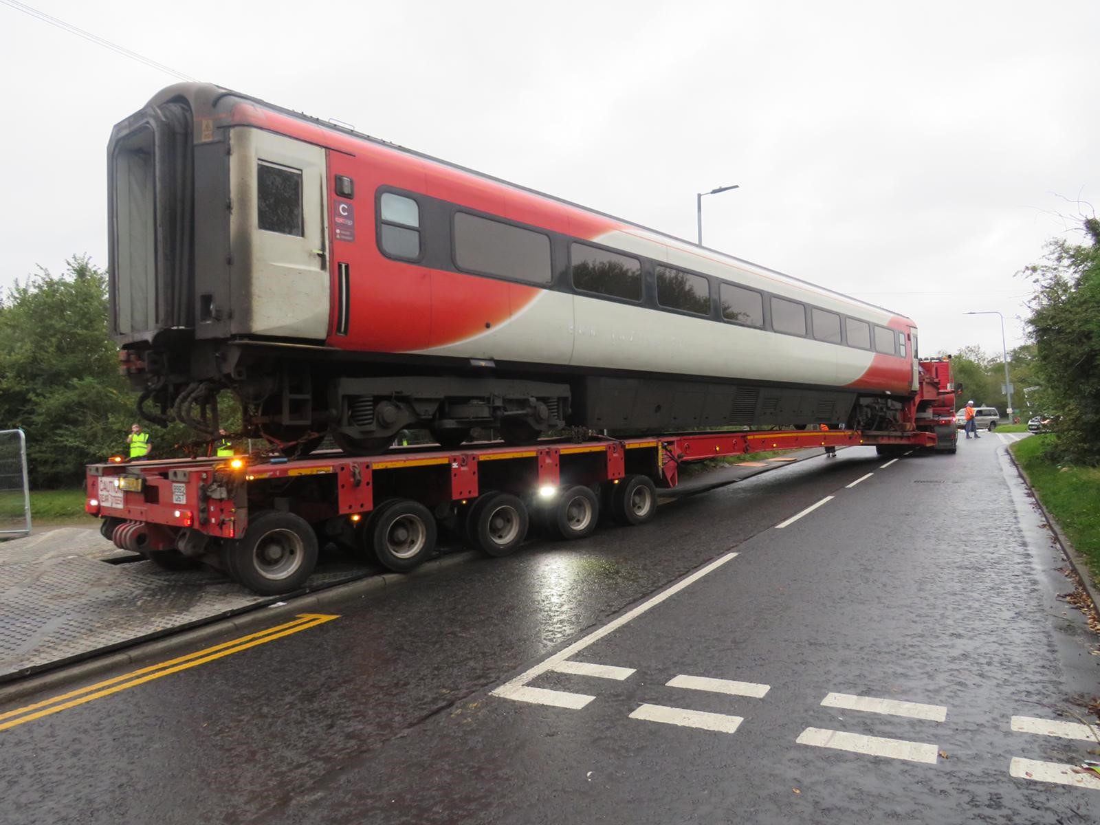 A lorry transporting a train carriage on a road.