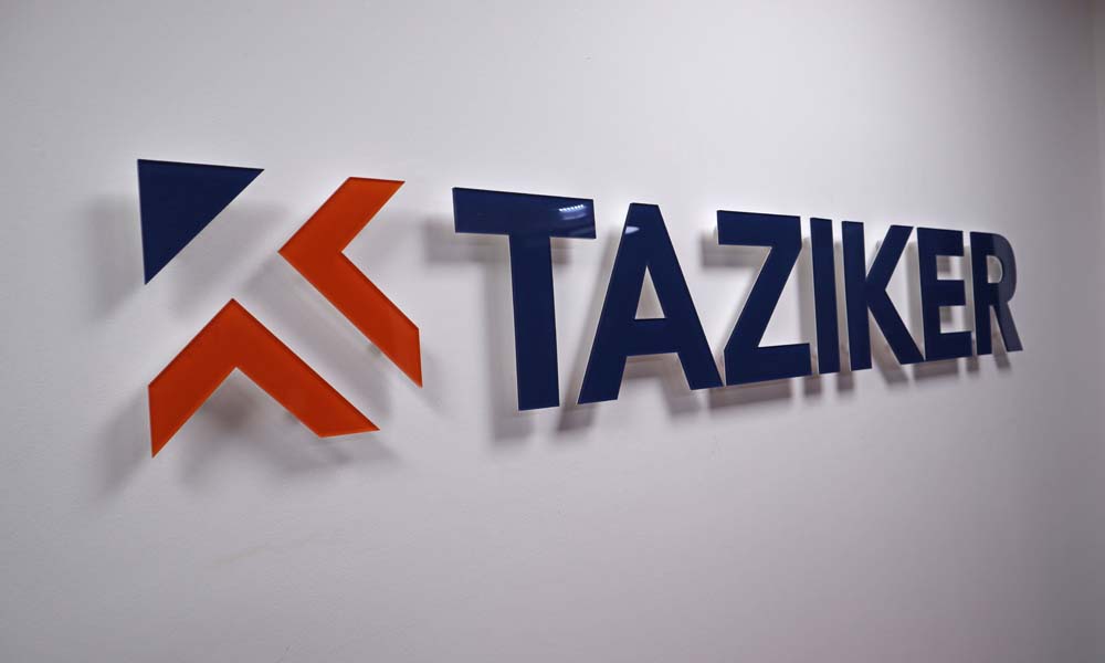 3D Taziker logo sign on white wall.